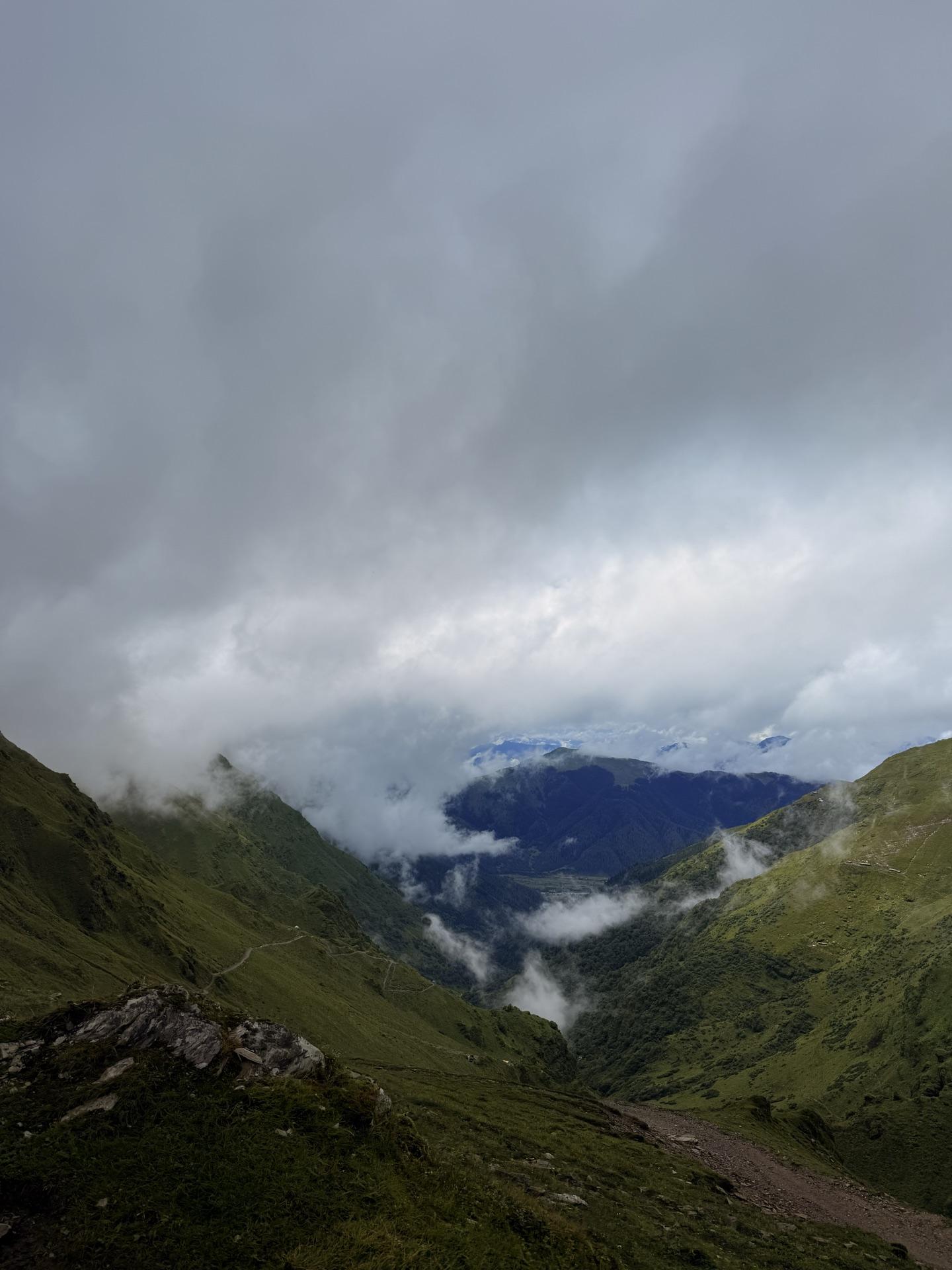 Dark ridgelines dissolving into a wall of white cloud