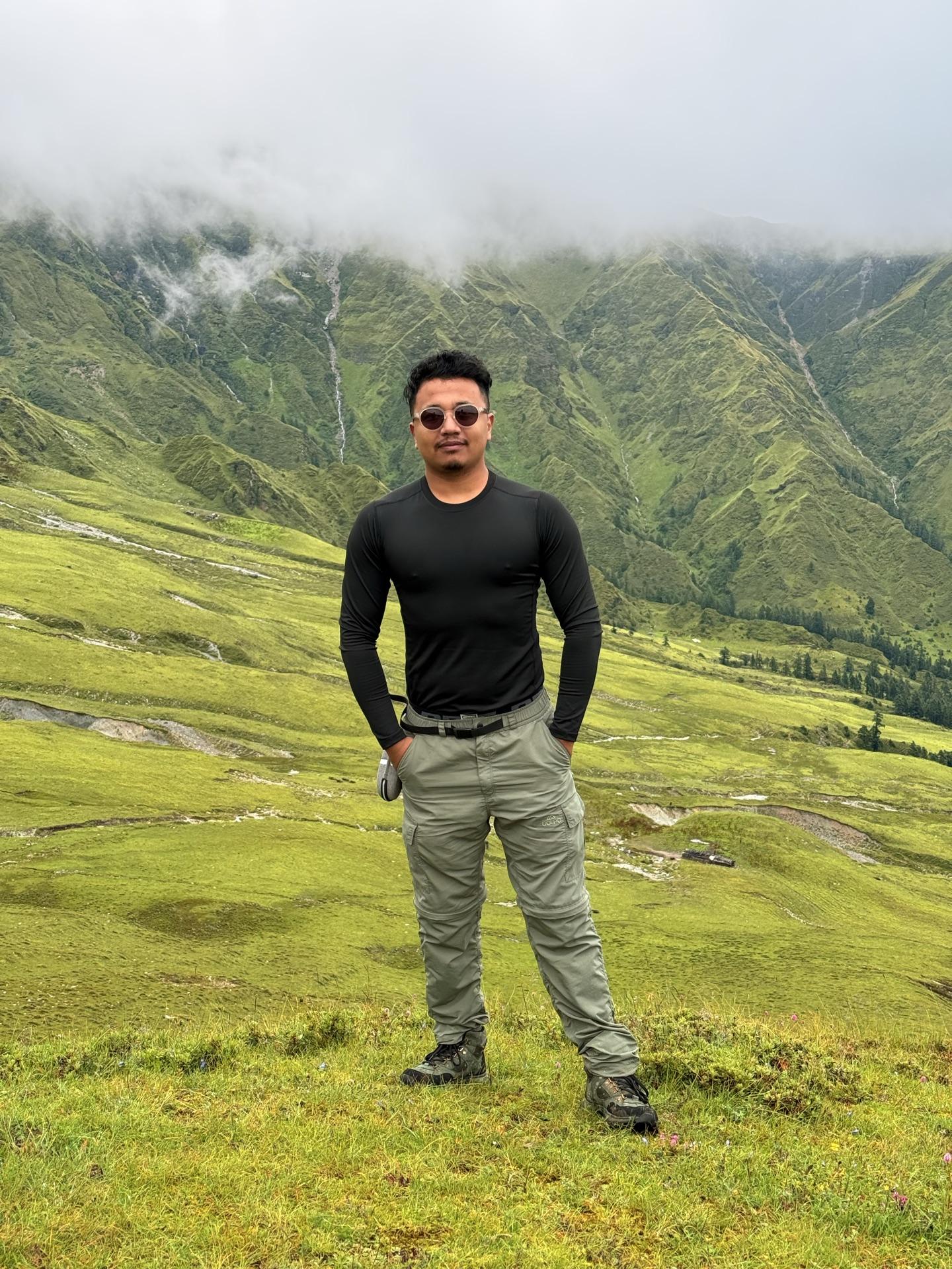 A friend in a black tee standing squarely on the buki meadow slope