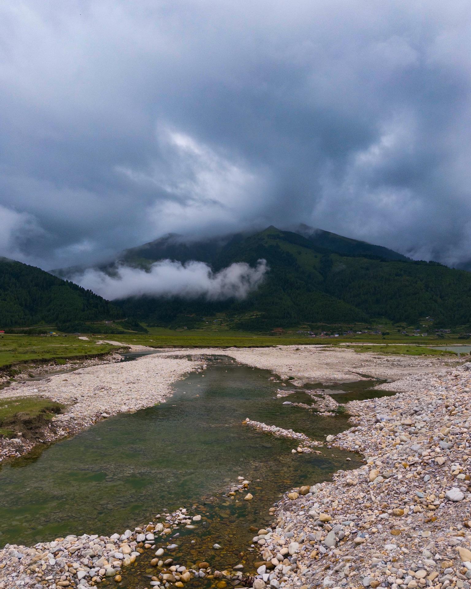 The braided river bed spreading across the valley under a heavy sky