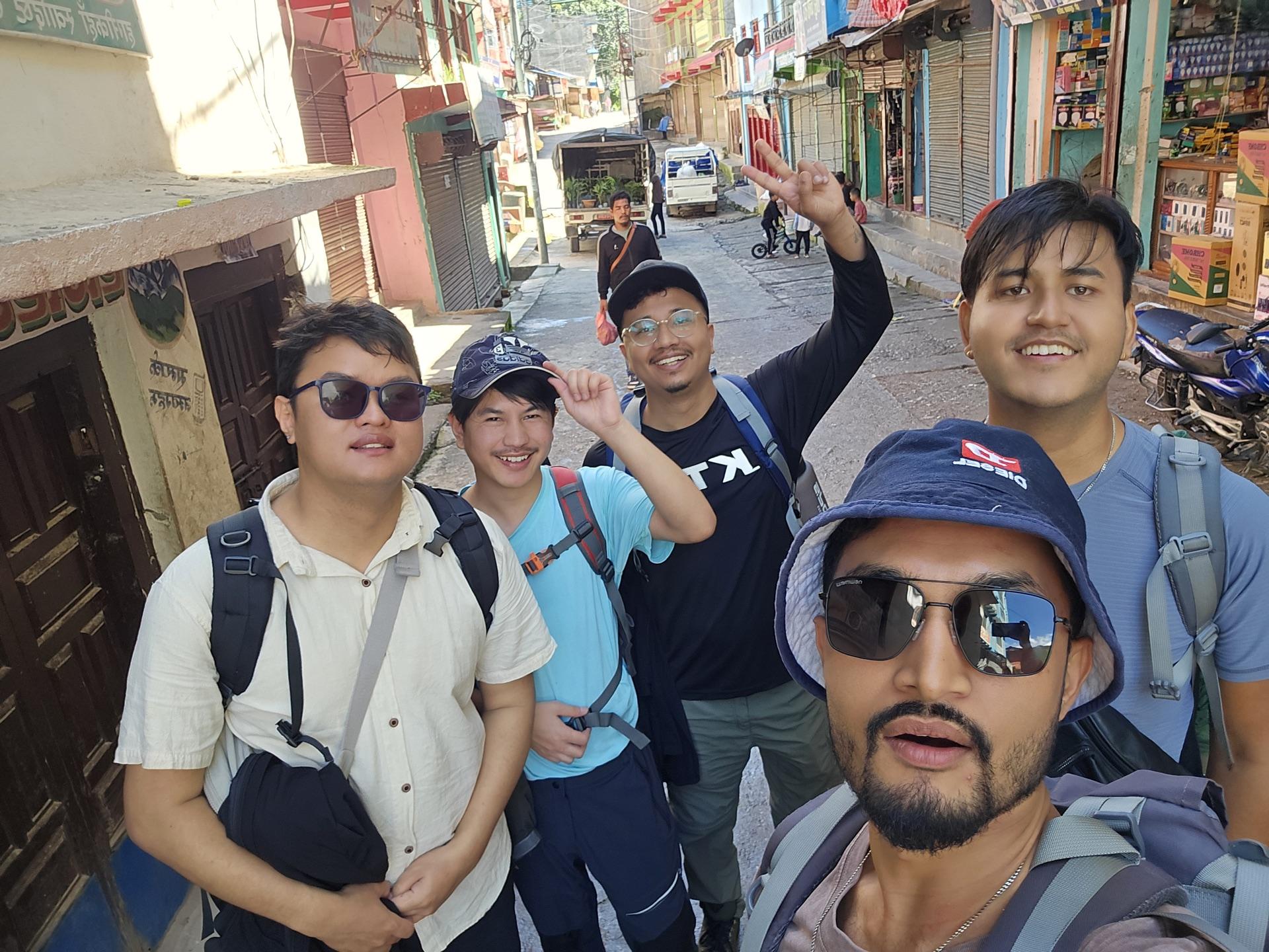 Five friends with backpacks taking a selfie in Burtibang's main street