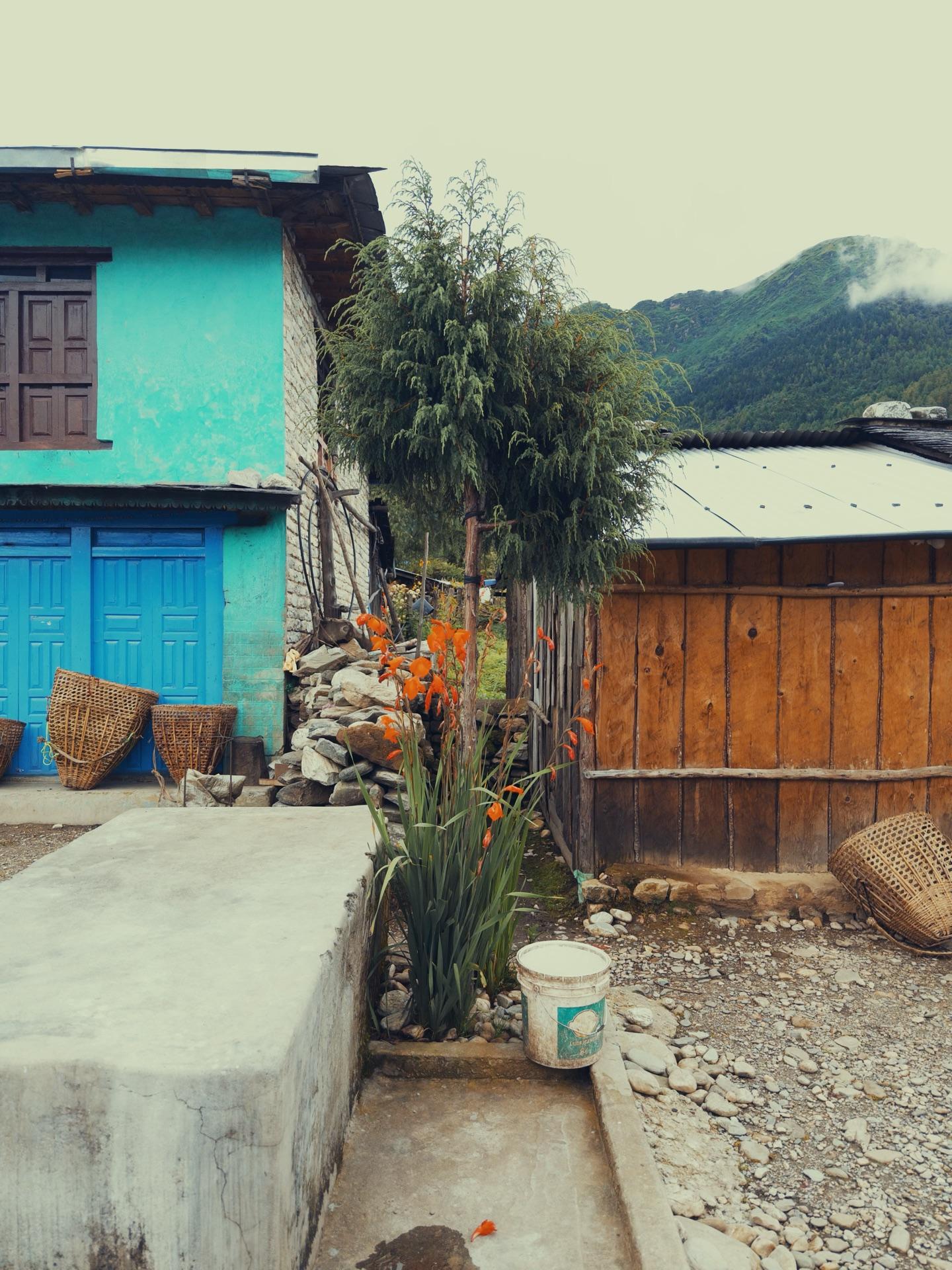 A teahouse with turquoise wooden windows in the village across the river