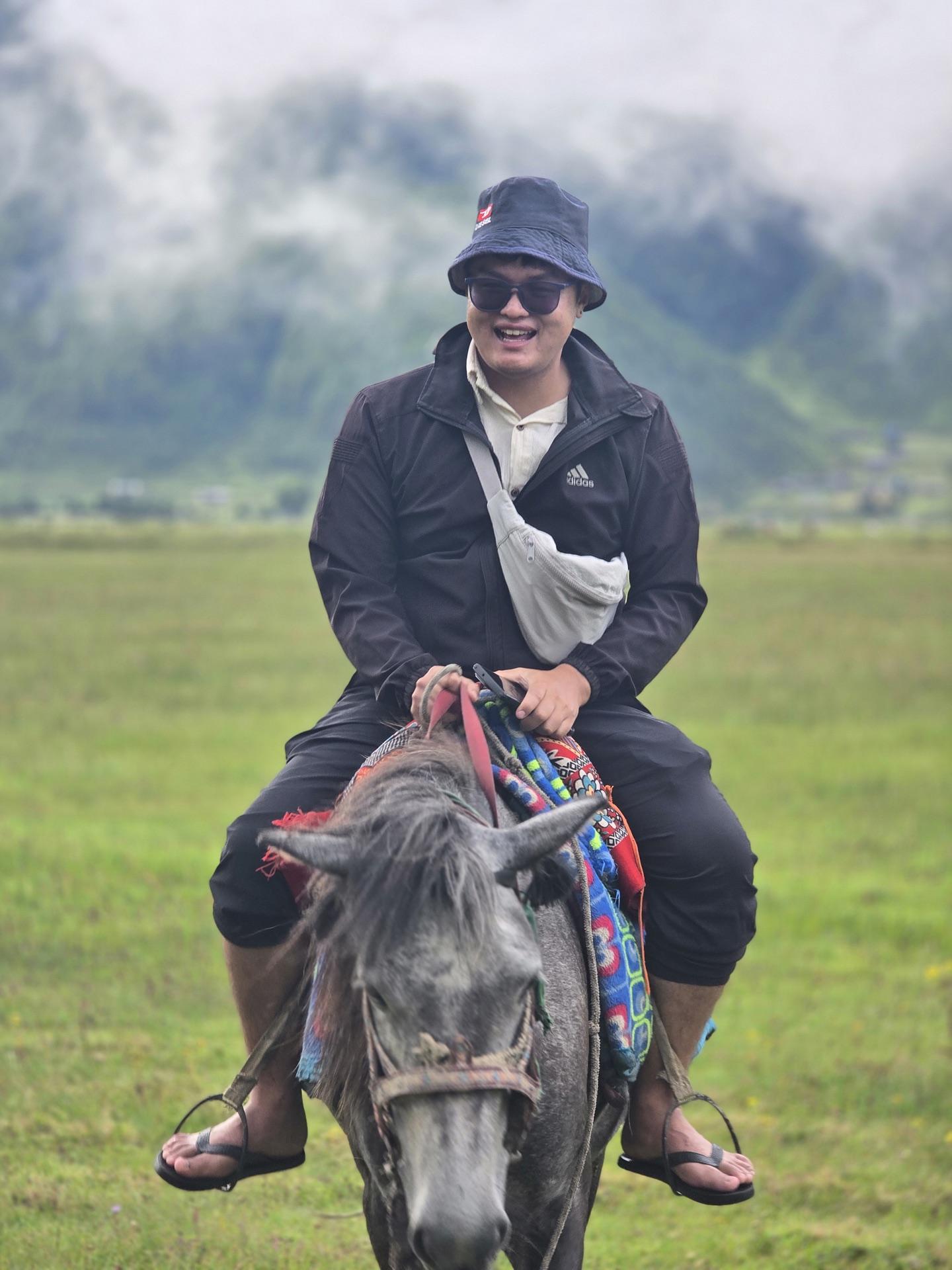 Raju in his bucket hat astride a white horse on the pasture, chappals still on