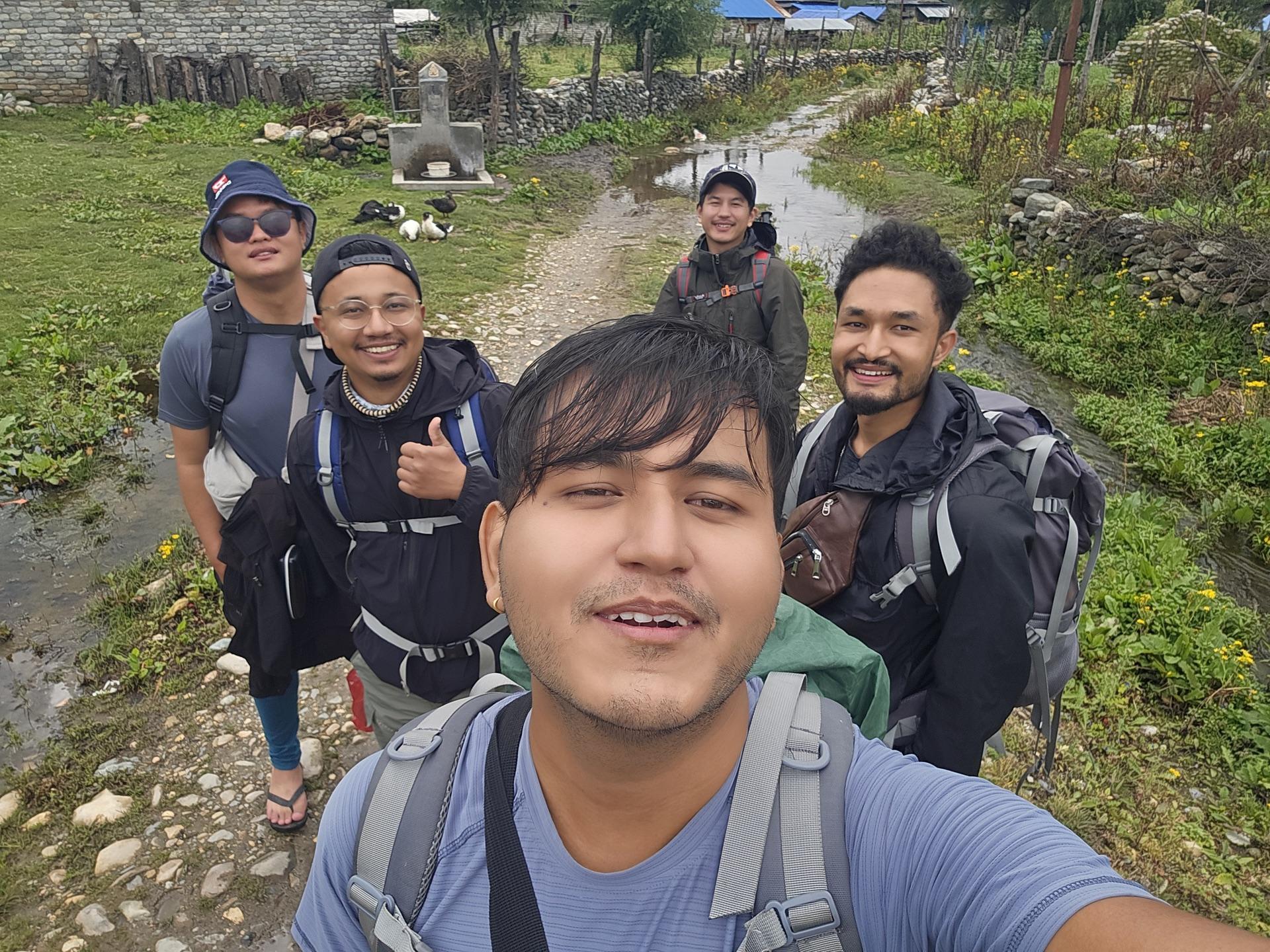 Selfie of the crew walking out of the village with full packs