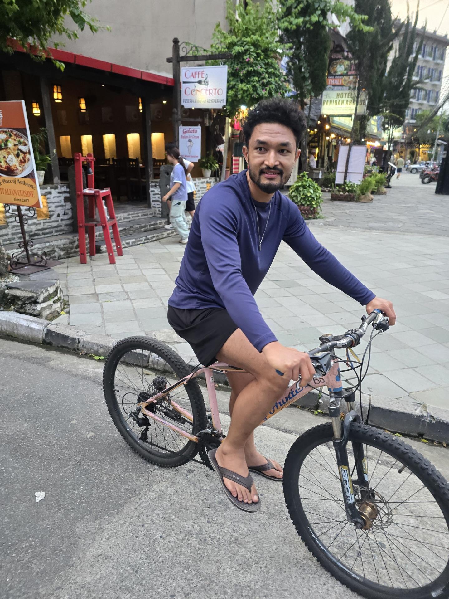 A friend on a rented bicycle on the Lakeside street at dusk