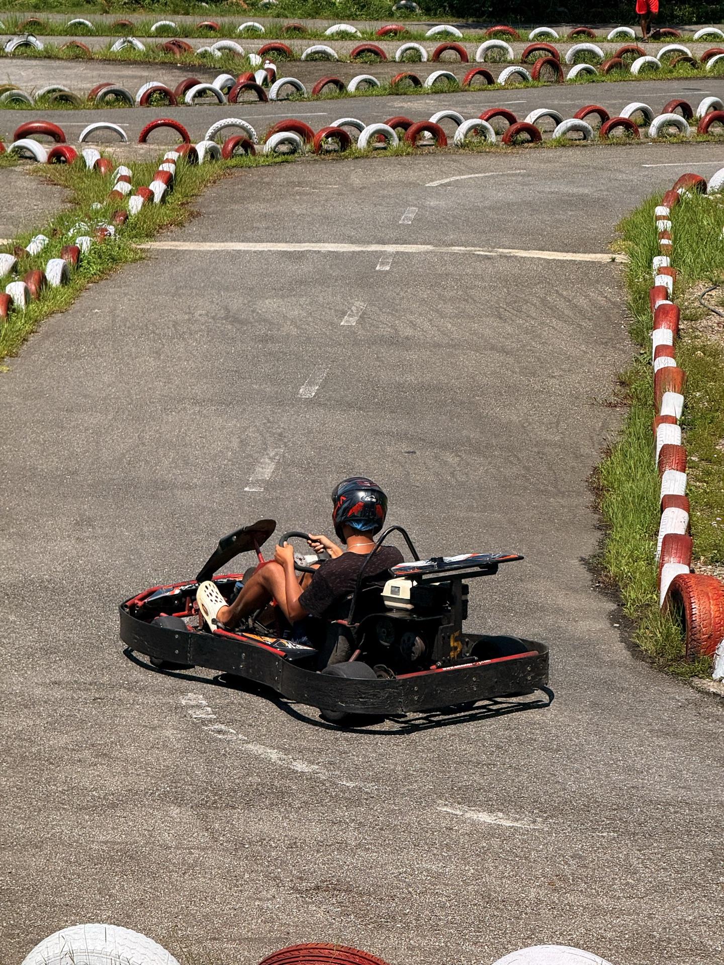 A friend leaning through the tire-lined straight in a go-kart