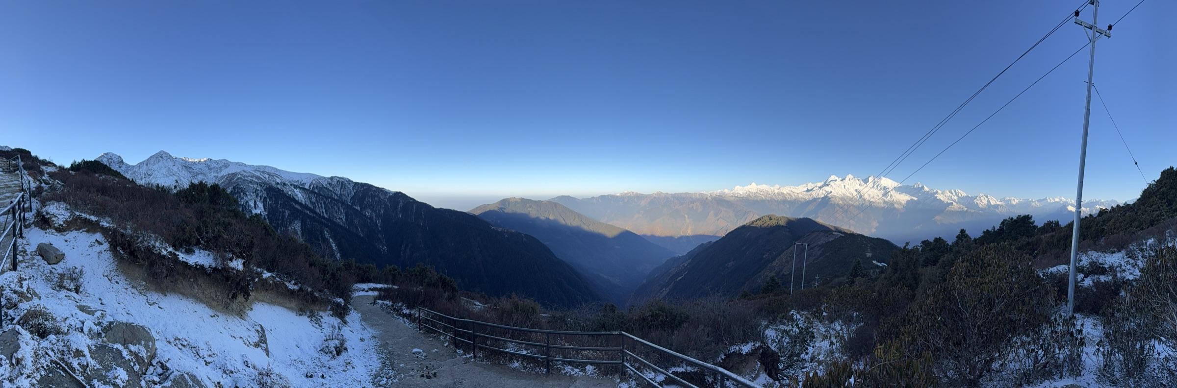 Panorama from Lauribina at dawn: snowy foreground, the valley dropping away, Ganesh Himal catching first light