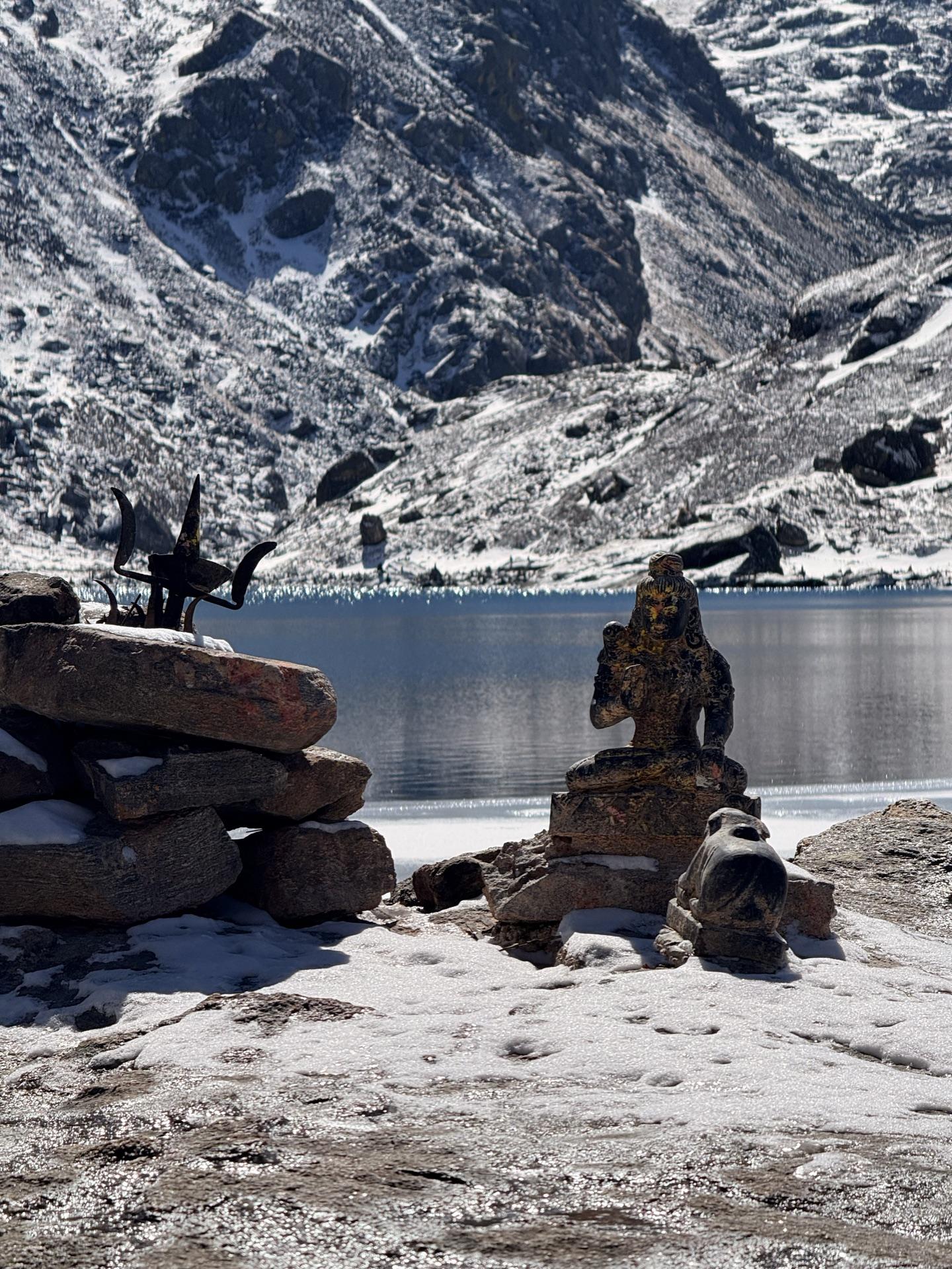 The Shiva statue at the shoreline with stone cairns