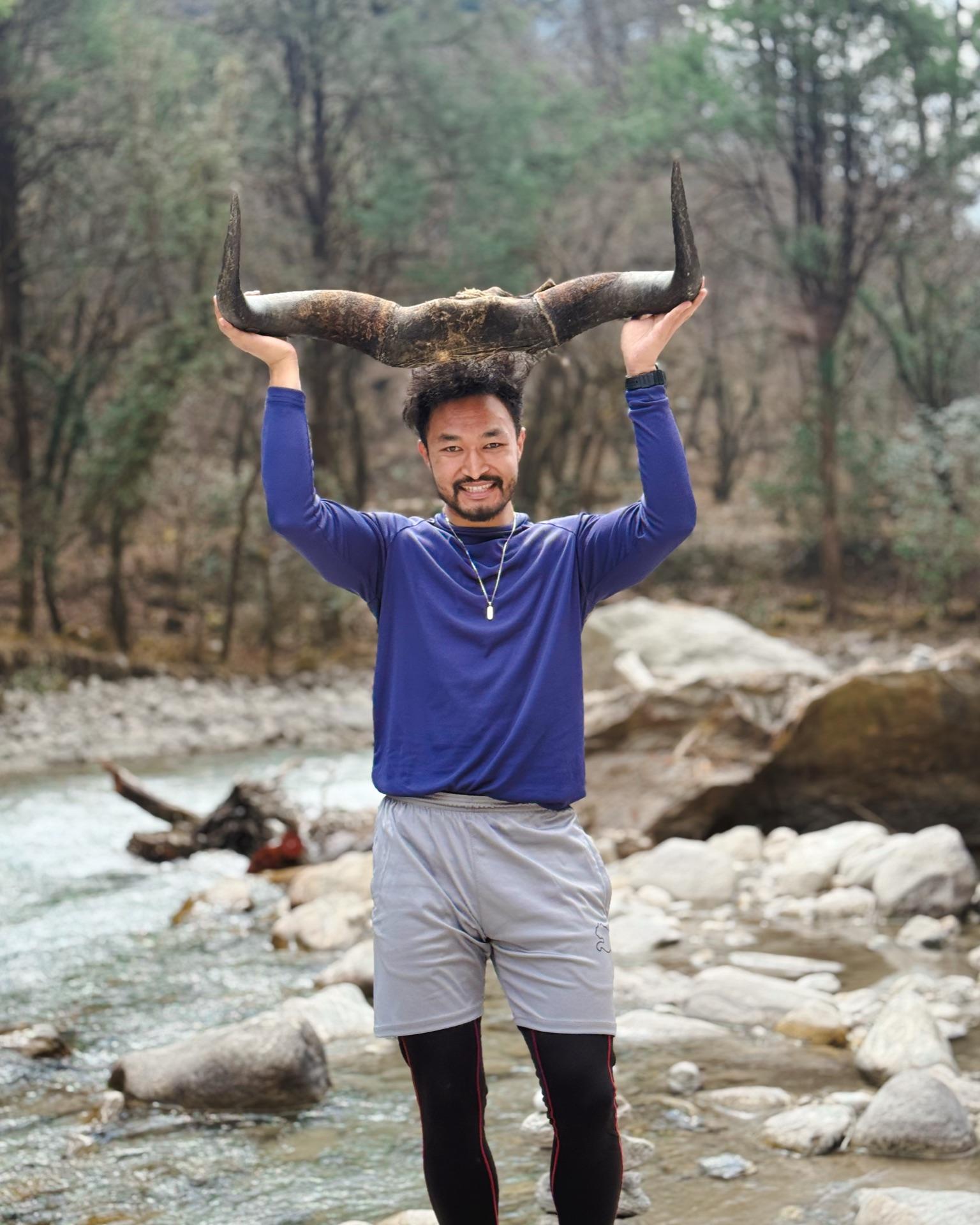 Raju hoisting the riverside teahouse's huge horn overhead, grinning