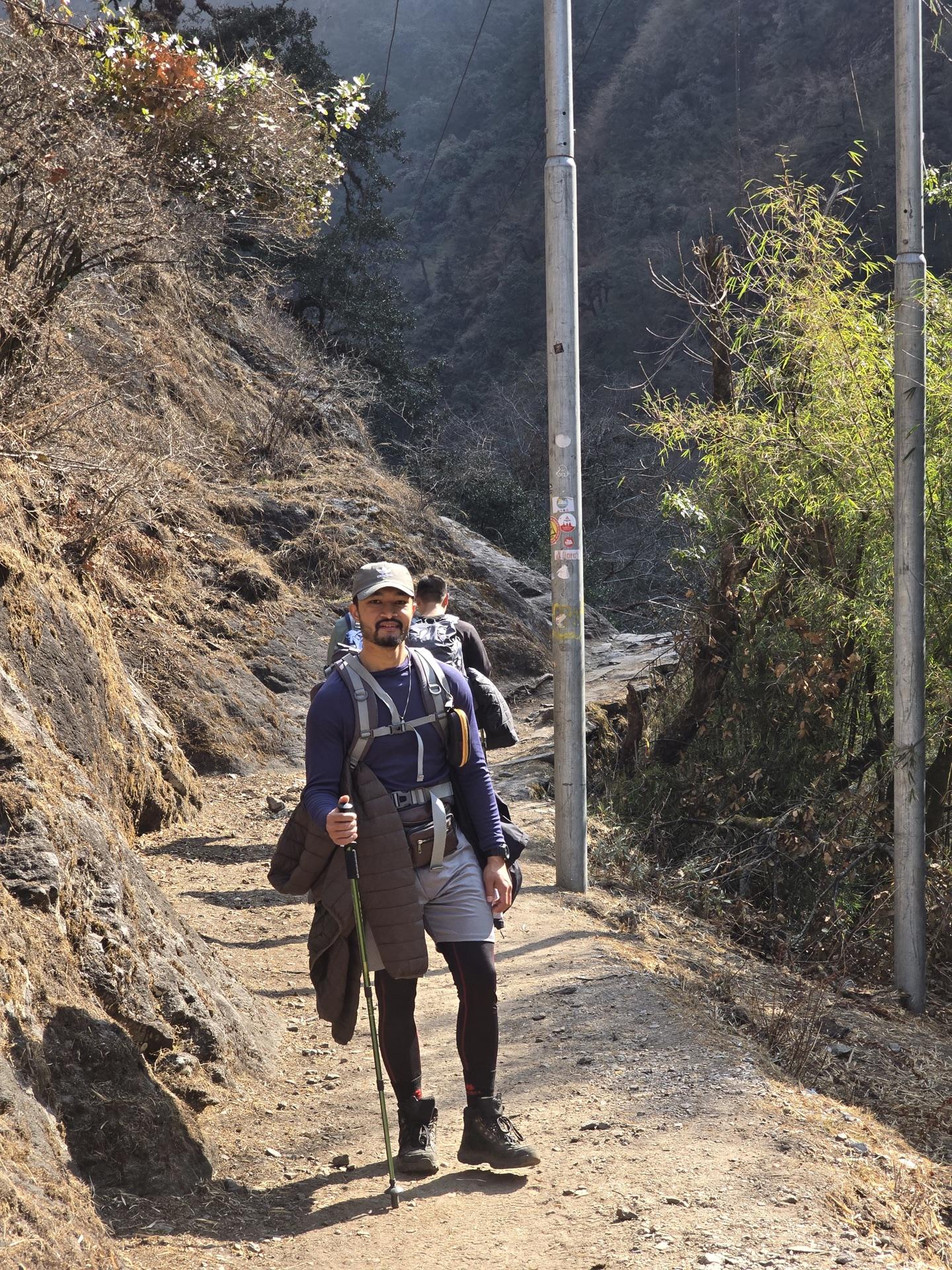 A friend walking the river trail with poles in morning light