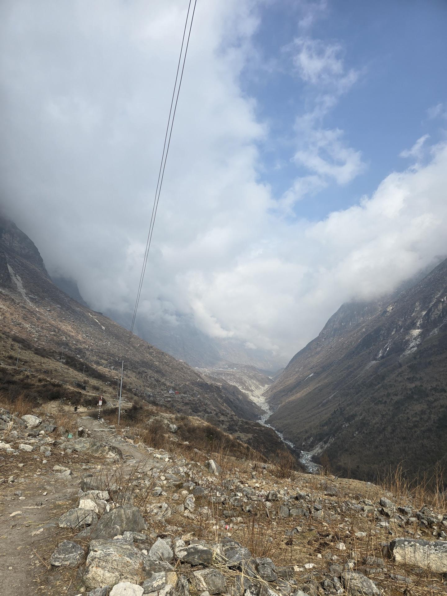 The valley opening wide ahead under afternoon cloud