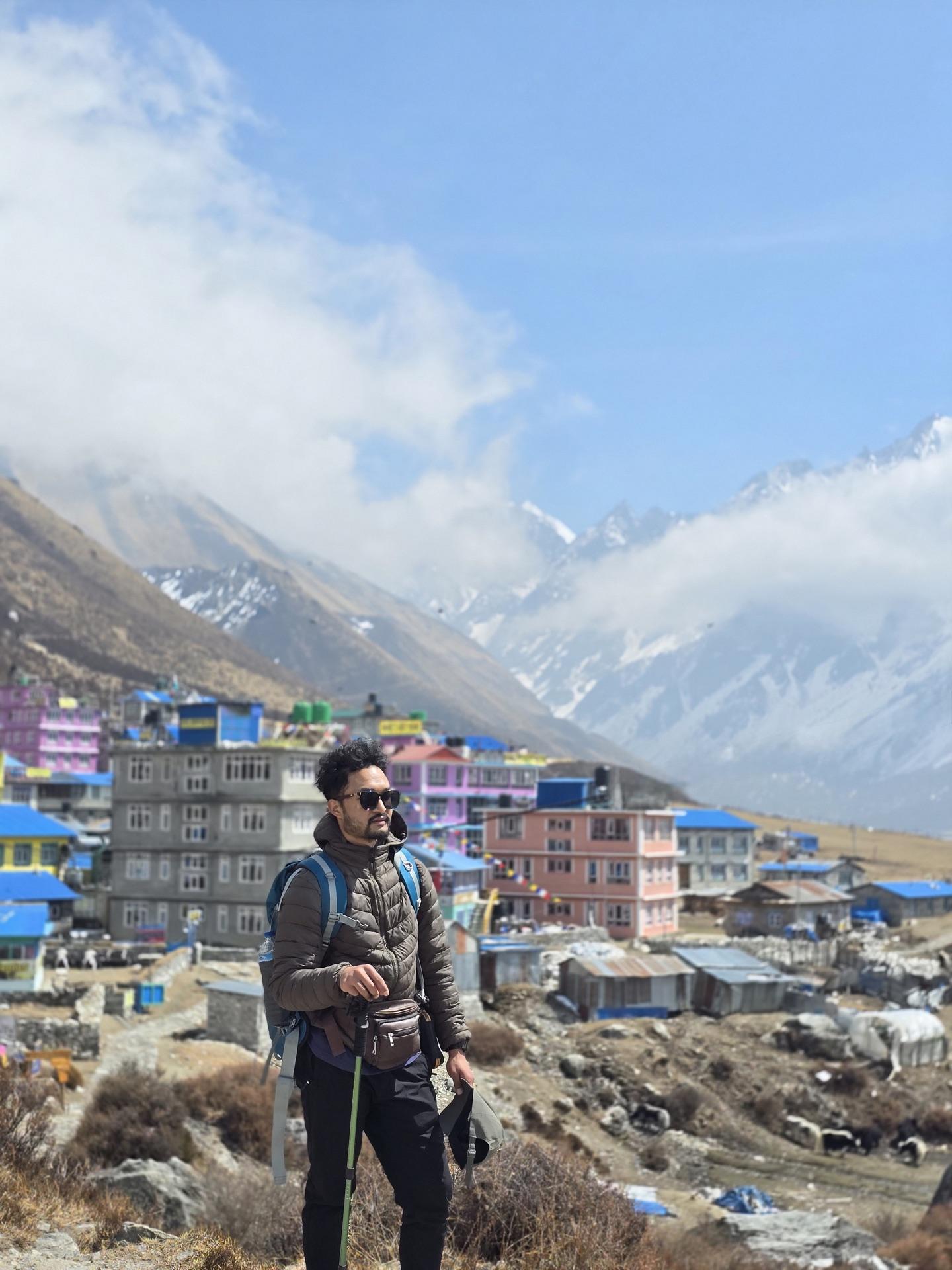 The colorful lodges of Kyanjin Gompa under snow peaks