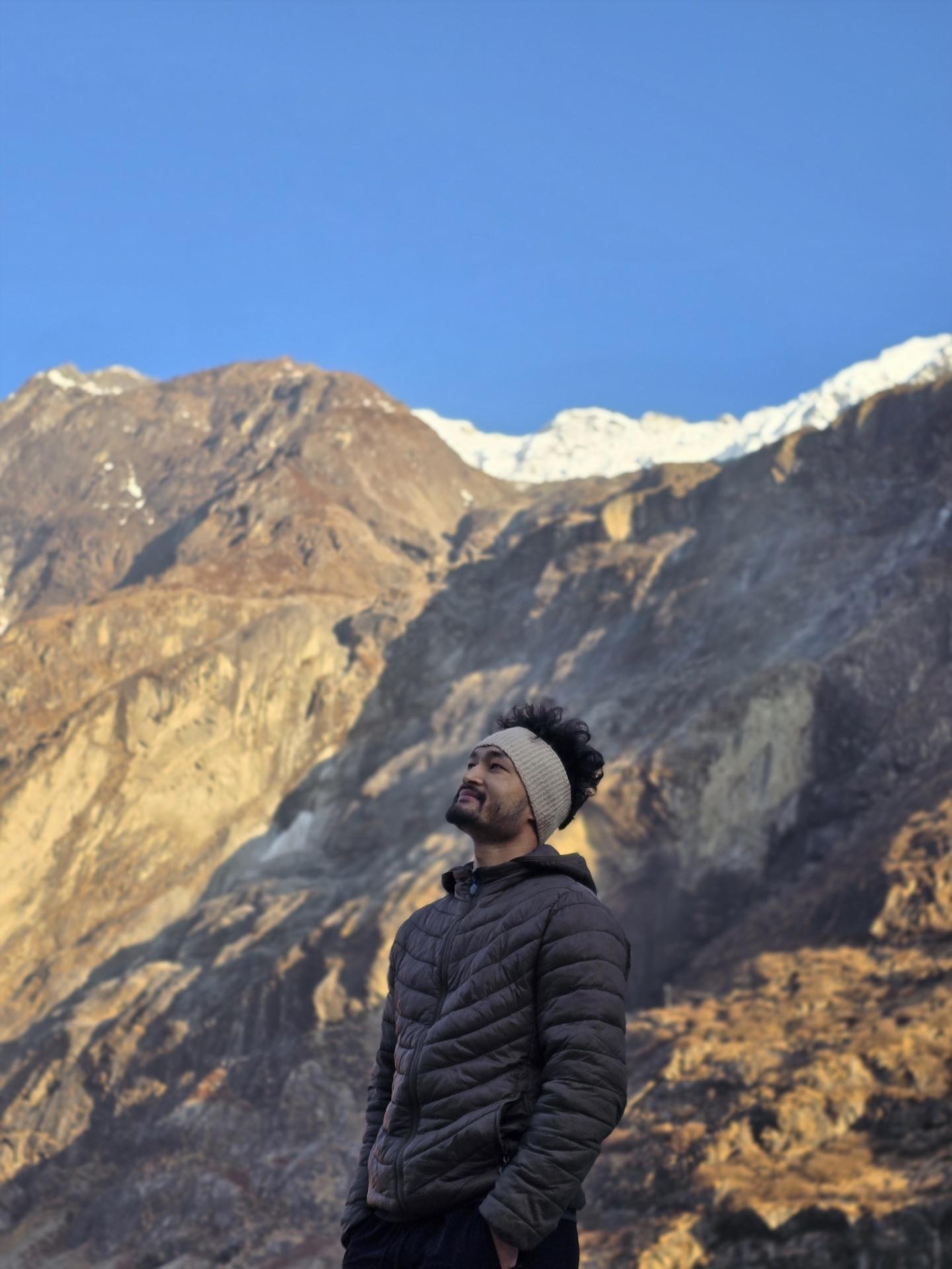 A friend perched on a boulder in first light above the trail