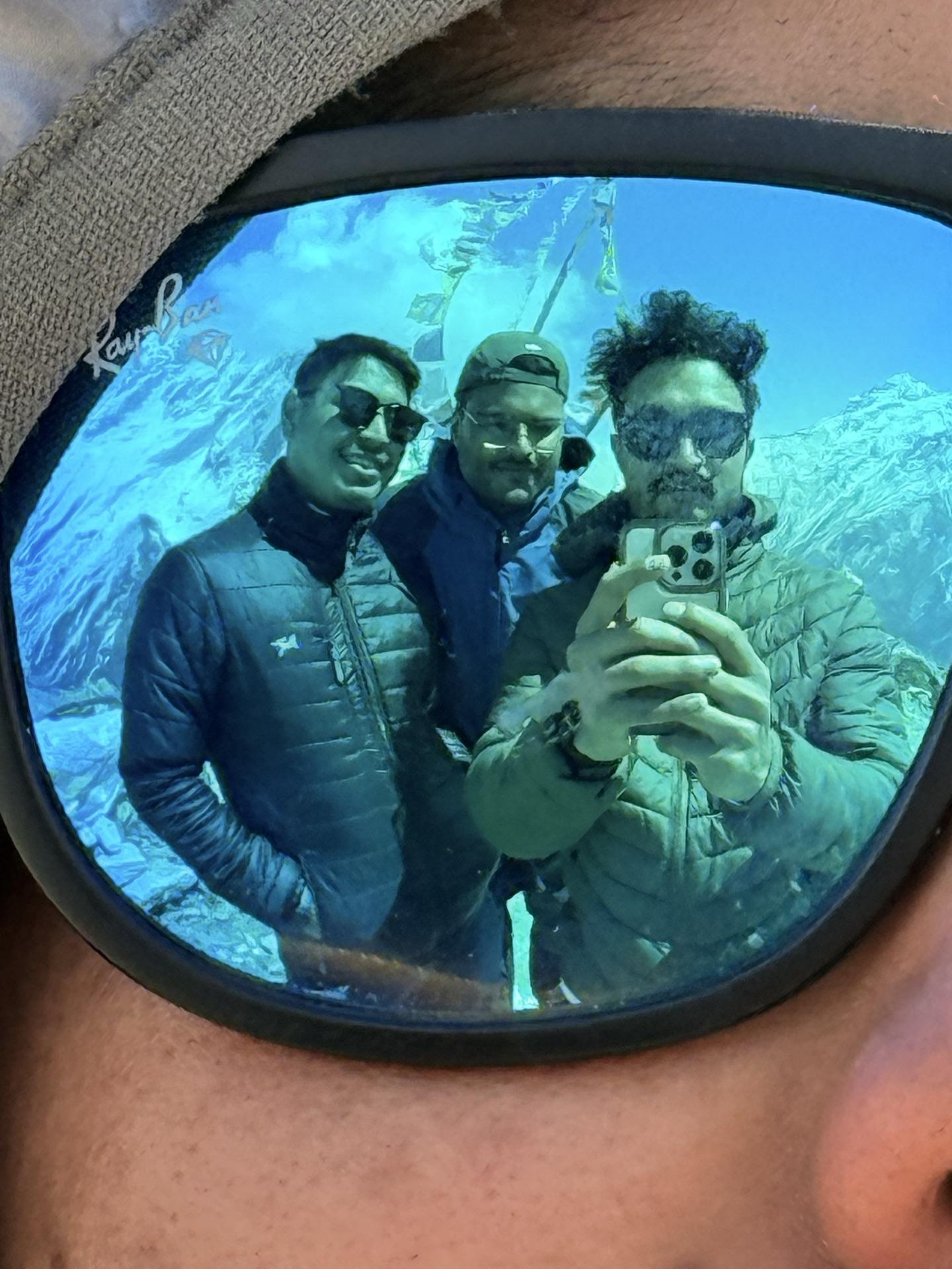 Three friends reflected in the mirror lens of a pair of sunglasses