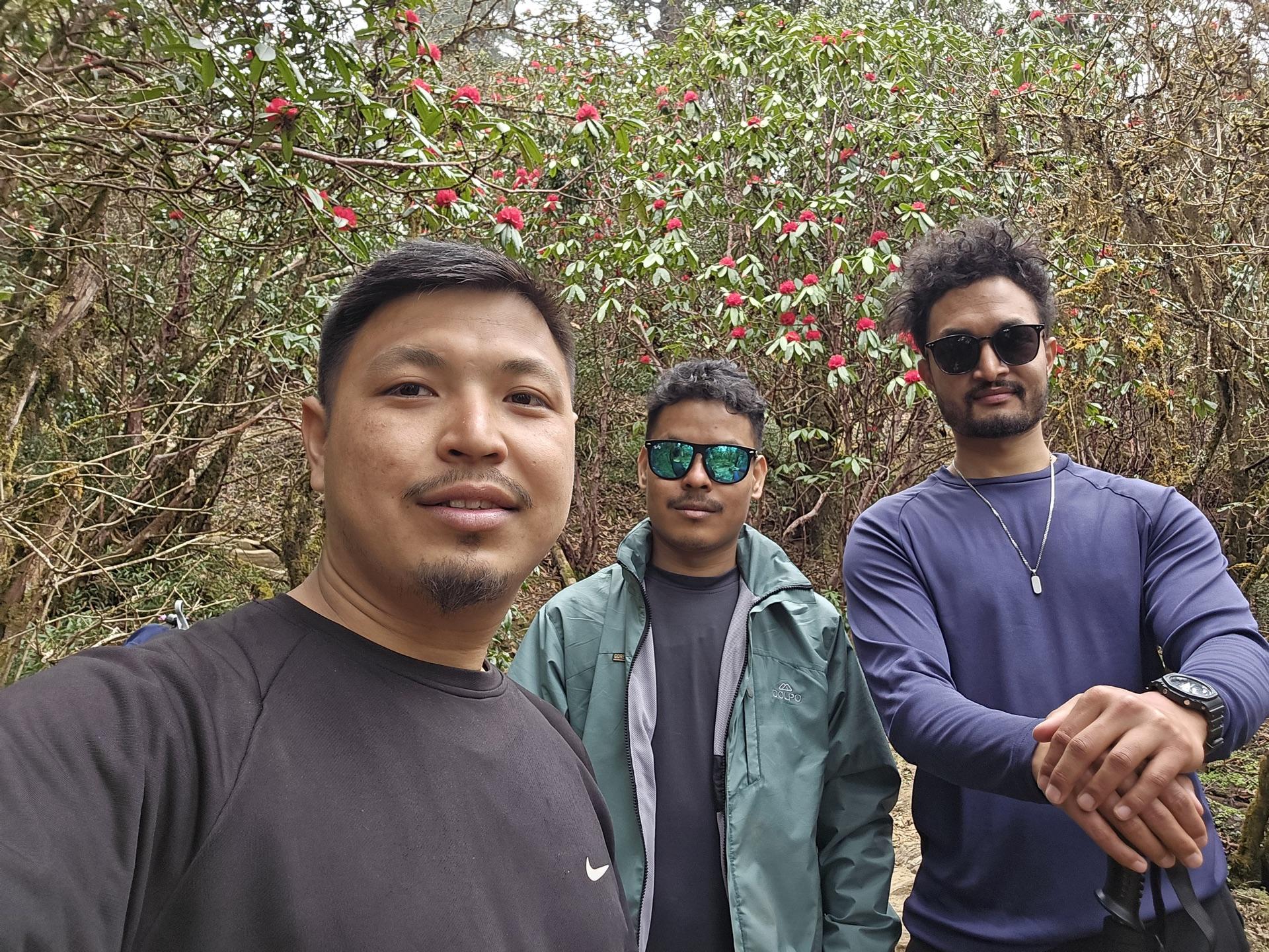 The three friends in a selfie among blooming rhododendrons