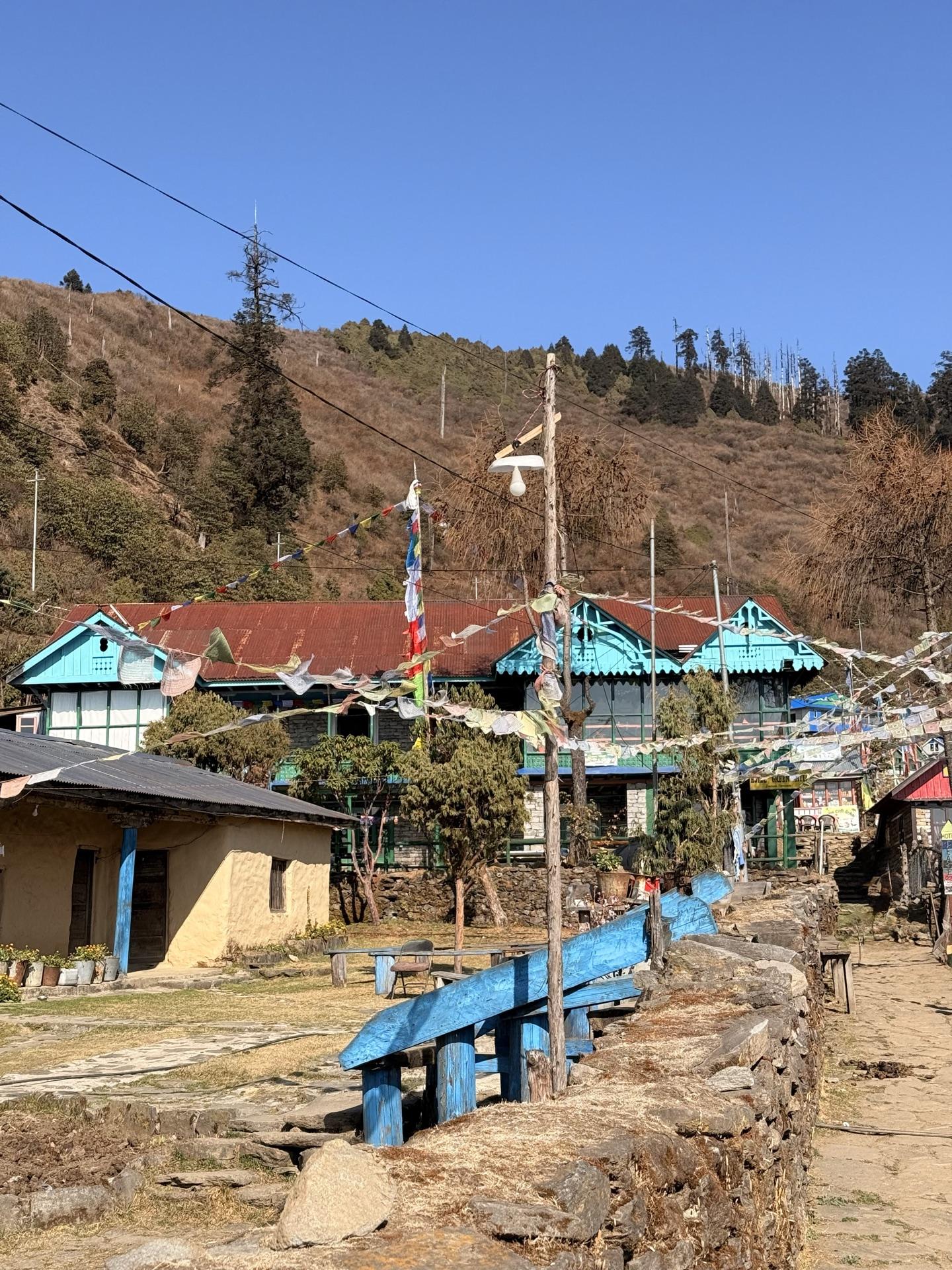 A stone lane through a blue-trimmed village near Dhunche