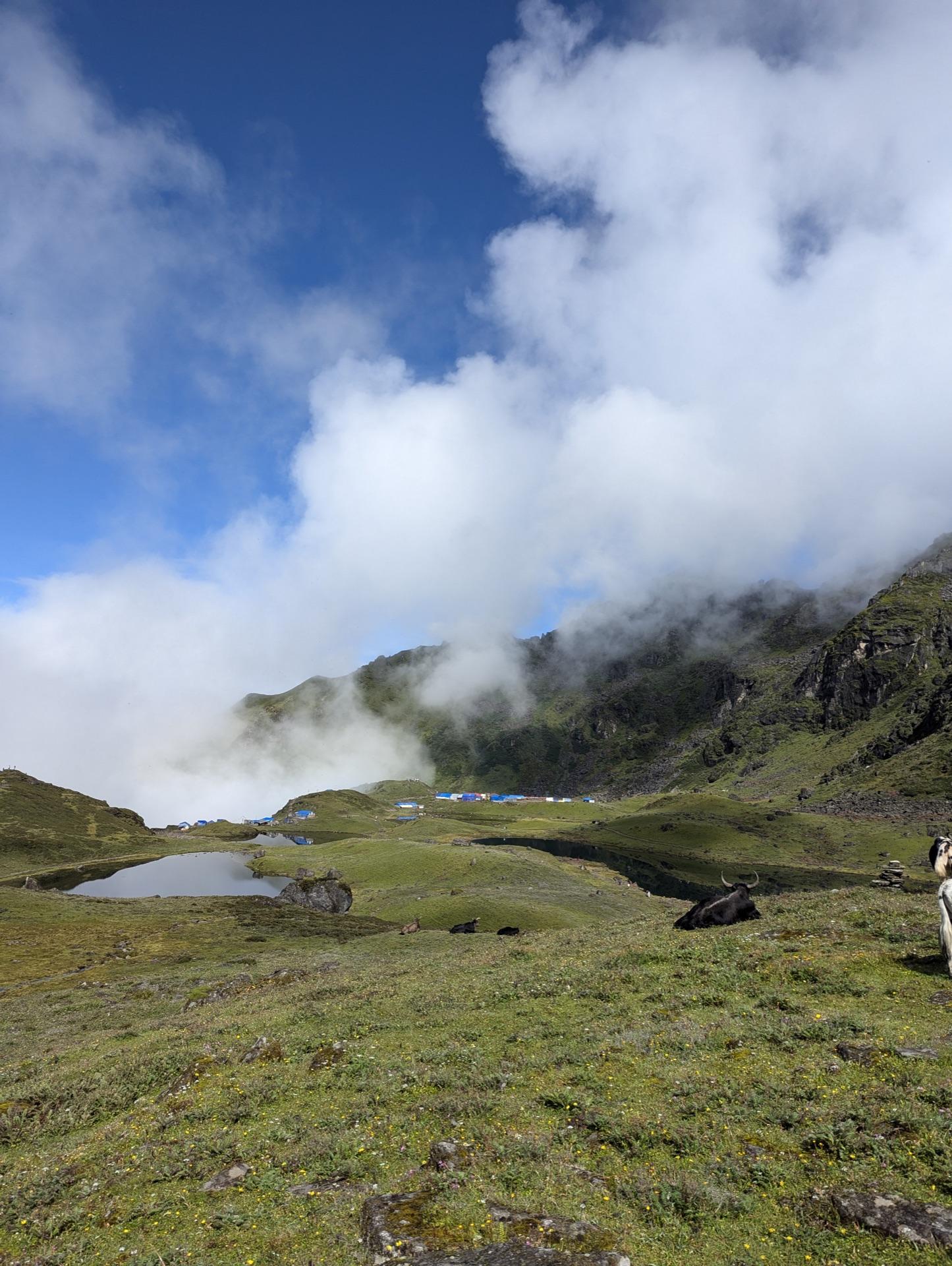 A wall of white cloud sliding back over the green basin