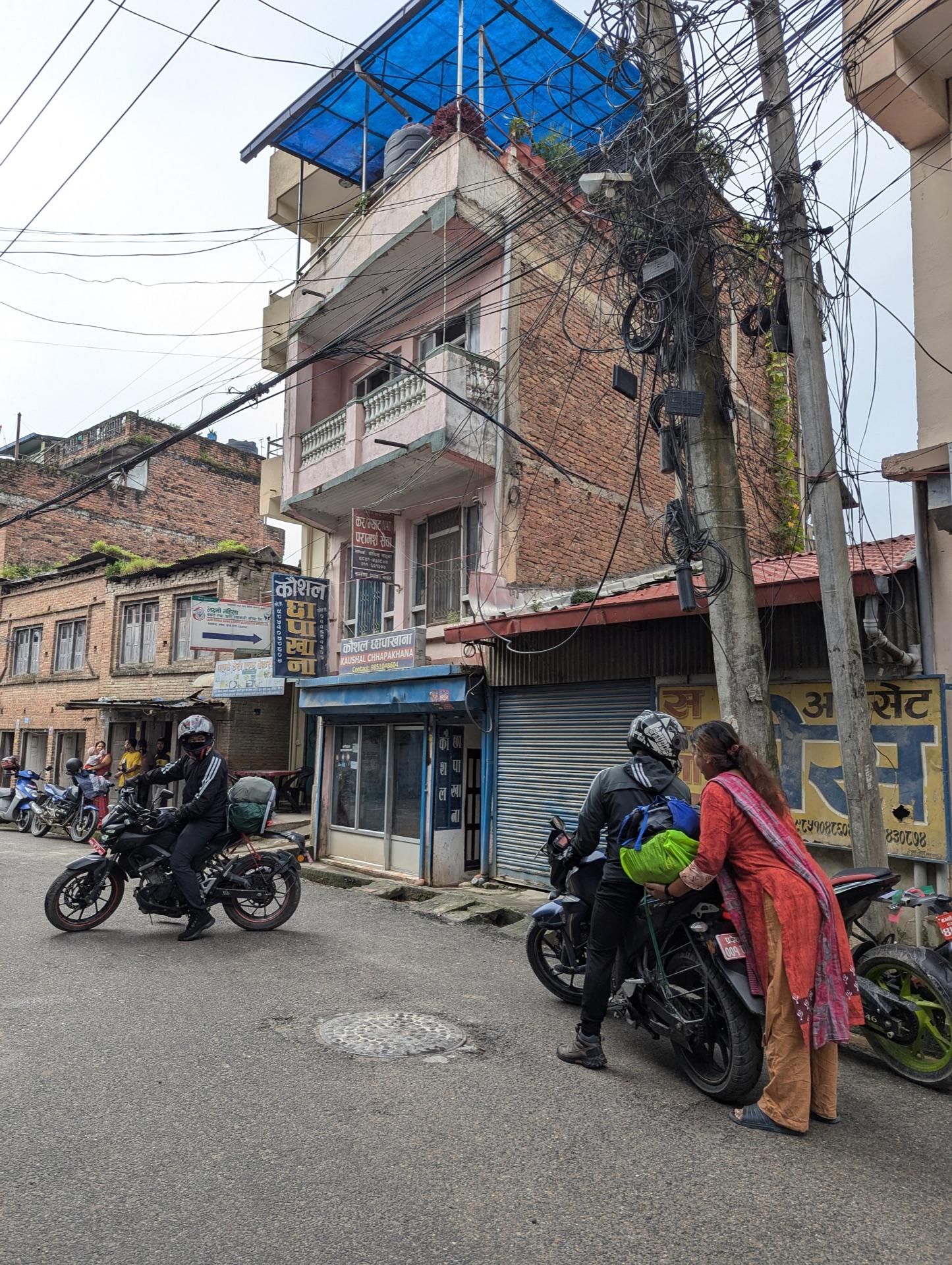 Motorbikes riding out through morning streets between brick houses