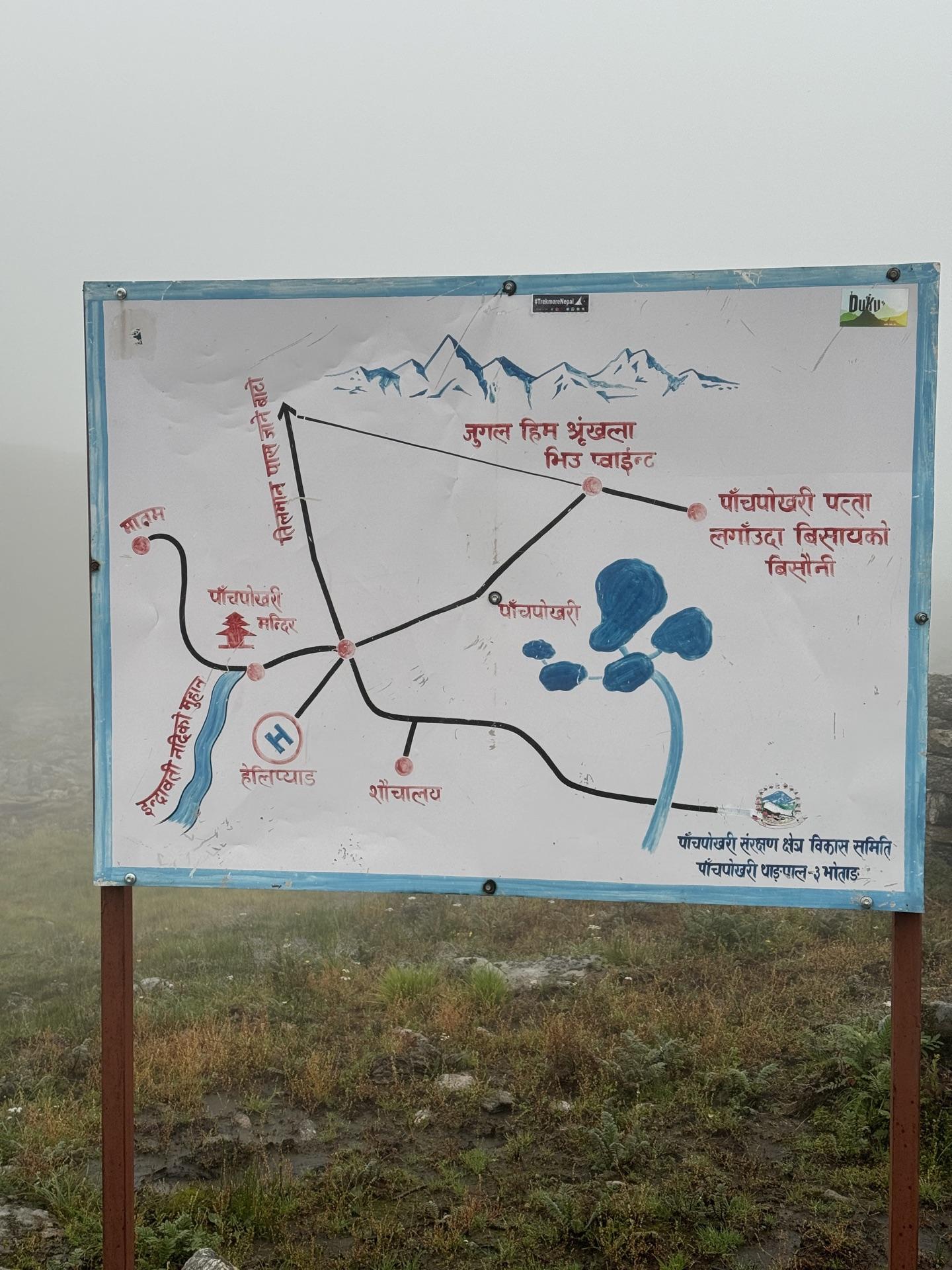 A painted map board of the five lakes standing in mist at the basin