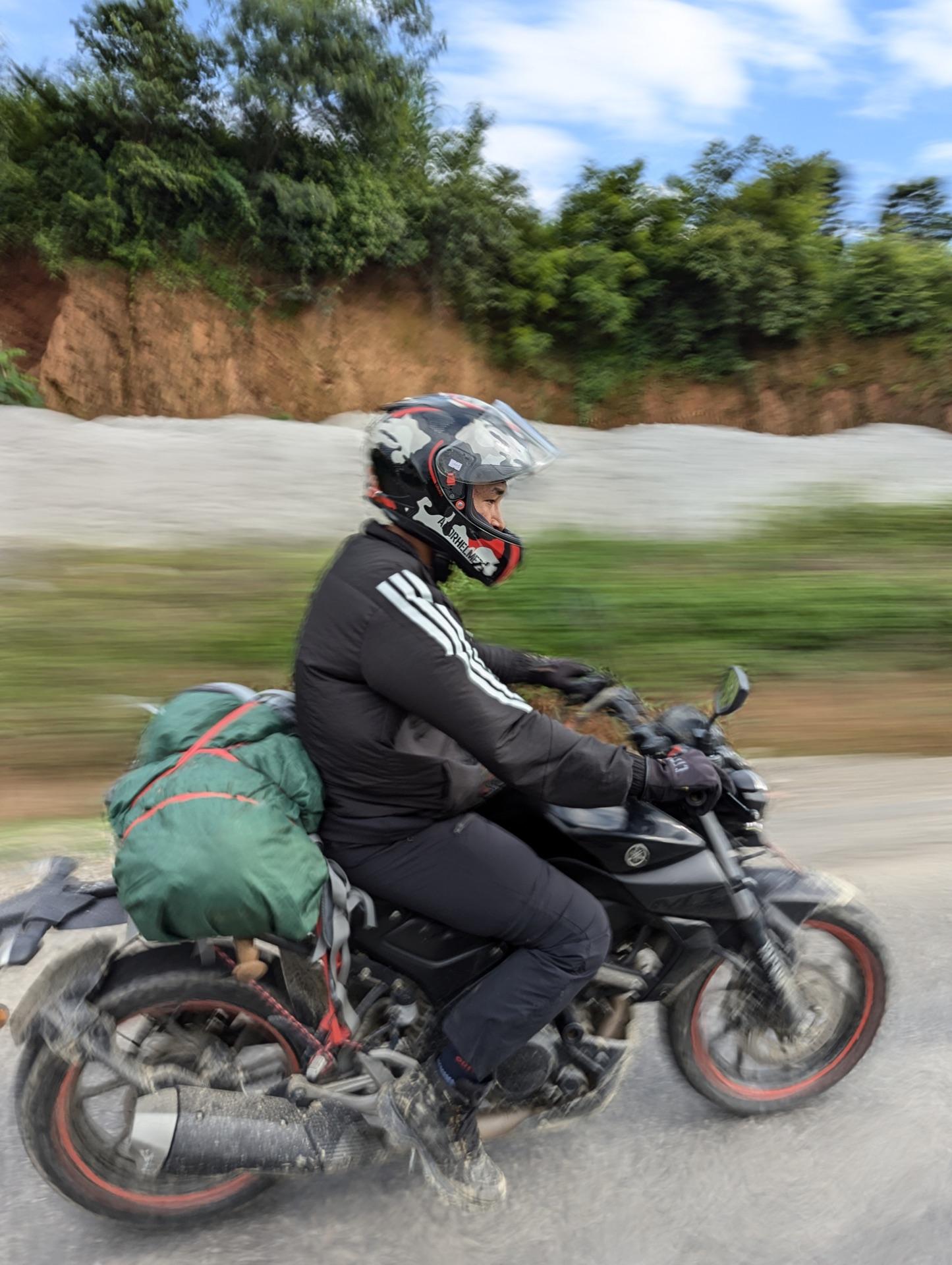 Action pan of a rider on the road home, the background streaked with speed